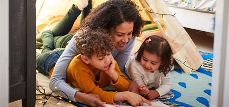 single mother reading with son and daughter